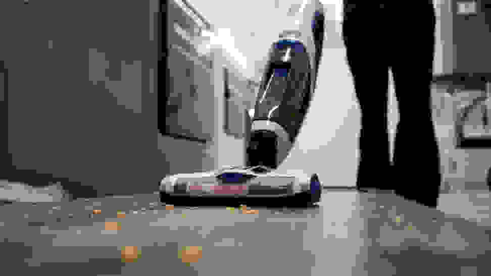 Person in black pants vacuums raw pasta off a bare floor