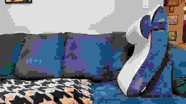 A navy and cream Qirroboni Orthopedic Indigo Bed Wedge Set on top of a blue suede couch.