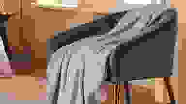 A throw blanket placed on a chair.