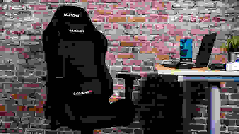 Our top pick for the best gaming chair, the black fabric akracing core EX, against a brick wall