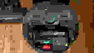 A black robot vacuum on a wood floor