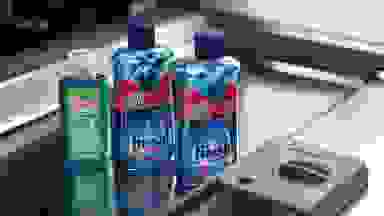 Bottles of rinse aid on an open dishwasher door.