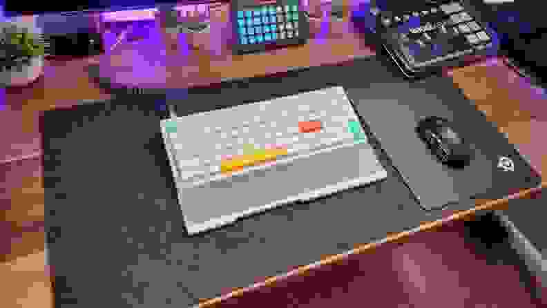 A colorful Nuphy Halo96 keyboard sits on a desktop, surrounded by podcasting and gaming gear