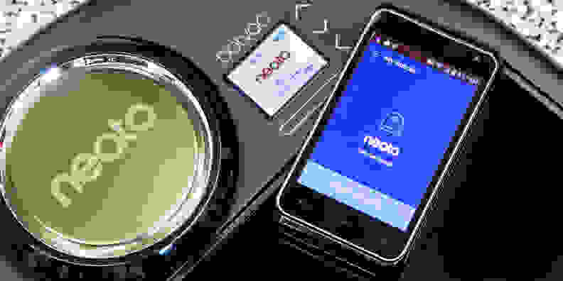 Phone sitting next to a robot vacuum.