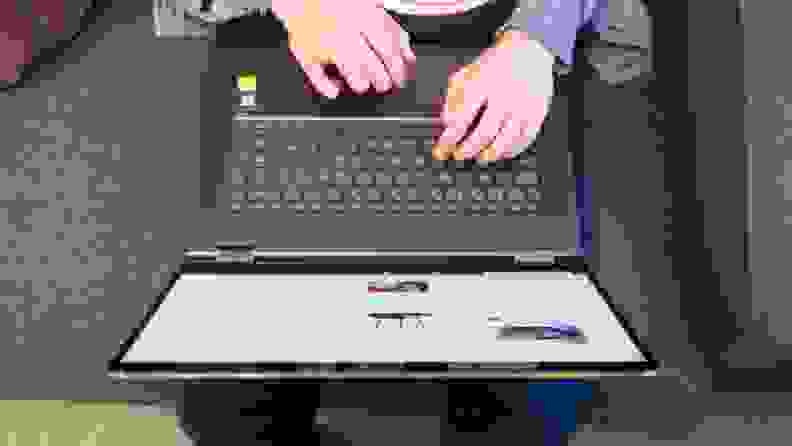 An overhead shot of a person using a laptop placed on their lap after cleaning it up from a spill.