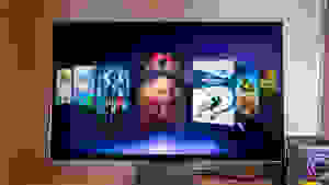 A 3D gaming monitor sits on a desk with video games gallery on its screen