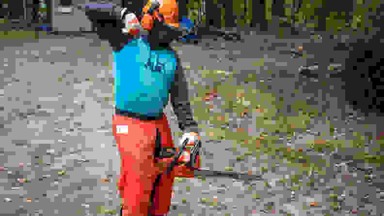 A man in safety gear starts up an Echo chainsaw