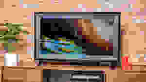 An OLED TV set sits on top of a credenza in a living room.