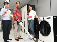 Three people standing next to the LG’s Universal Up equipment.